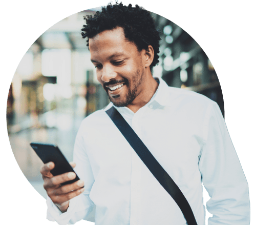 Black man smiling and scrolling on his smartphone